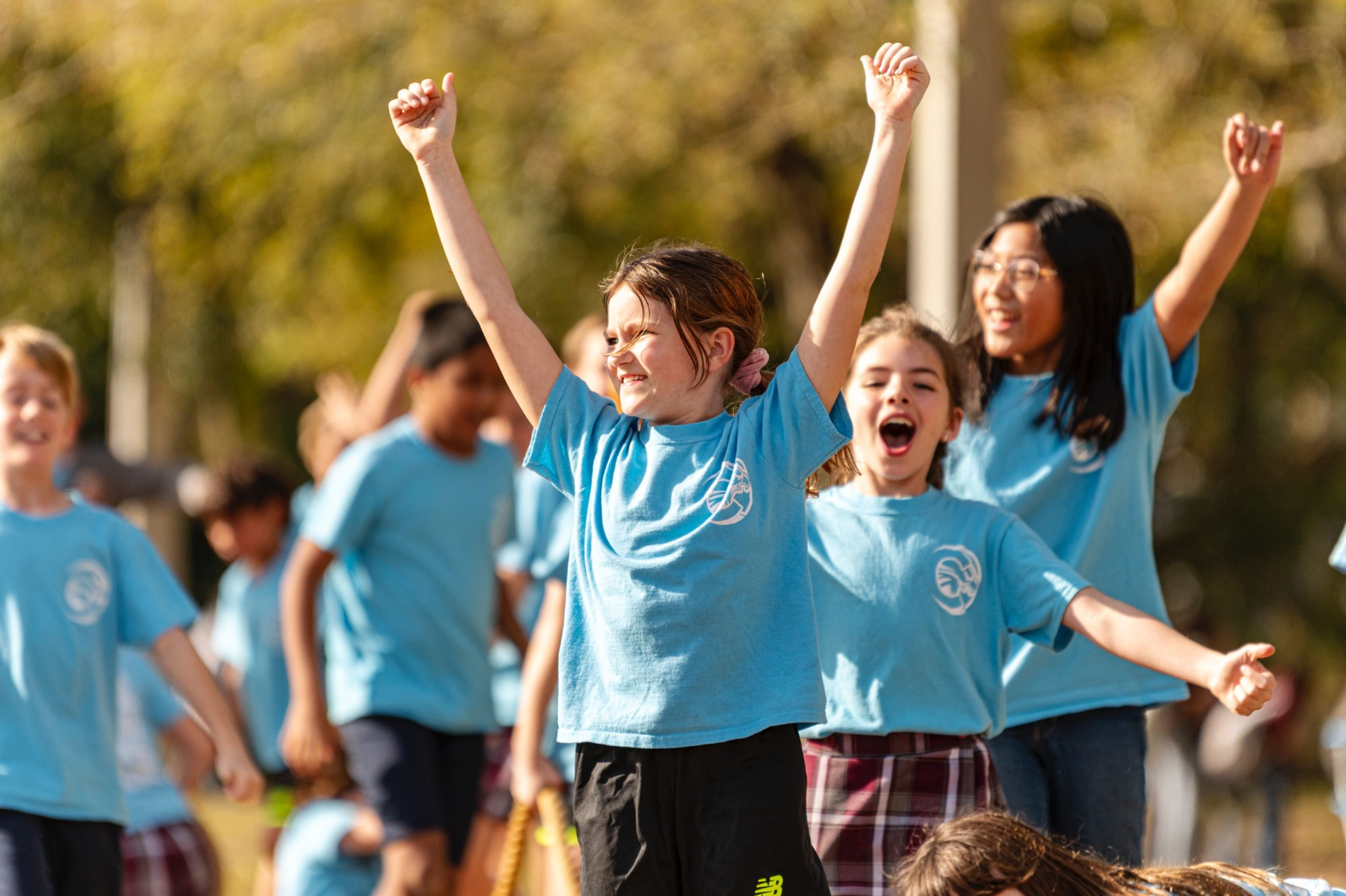 Elementary CCA students cheering with their arms raised at Field Day